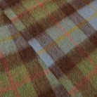 Close-up of a plaid fabric with brown, green, and red patterns.