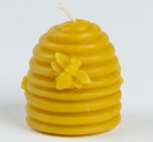 Yellow beehive-shaped candle with a bee on a white background