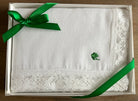 White lace handkerchief with a green shamrock  in a box on a wooden surface