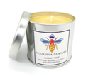 Candle in a metal tin with a label featuring a bee design on a white background