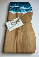 Wooden cutting board with ocean wave design and a tag on a white background