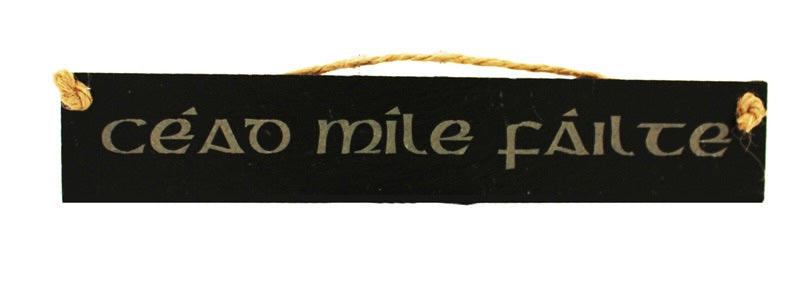 Black slate sign with 'cáod mile fälte' text on a white background