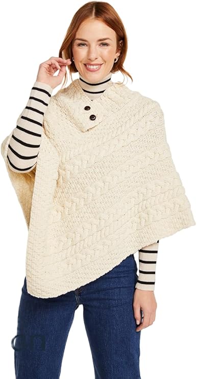 Woman wearing a cream-colored poncho over a striped shirt with a white background