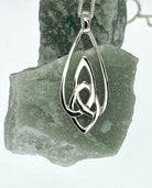 Silver Celtic knot pendant on a stone background