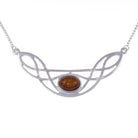 Silver necklace with a Celtic knot design and amber stone on a white background