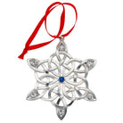 Silver snowflake ornament with blue gem and red ribbon on a white background