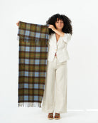 Woman holding a plaid scarf against a white background