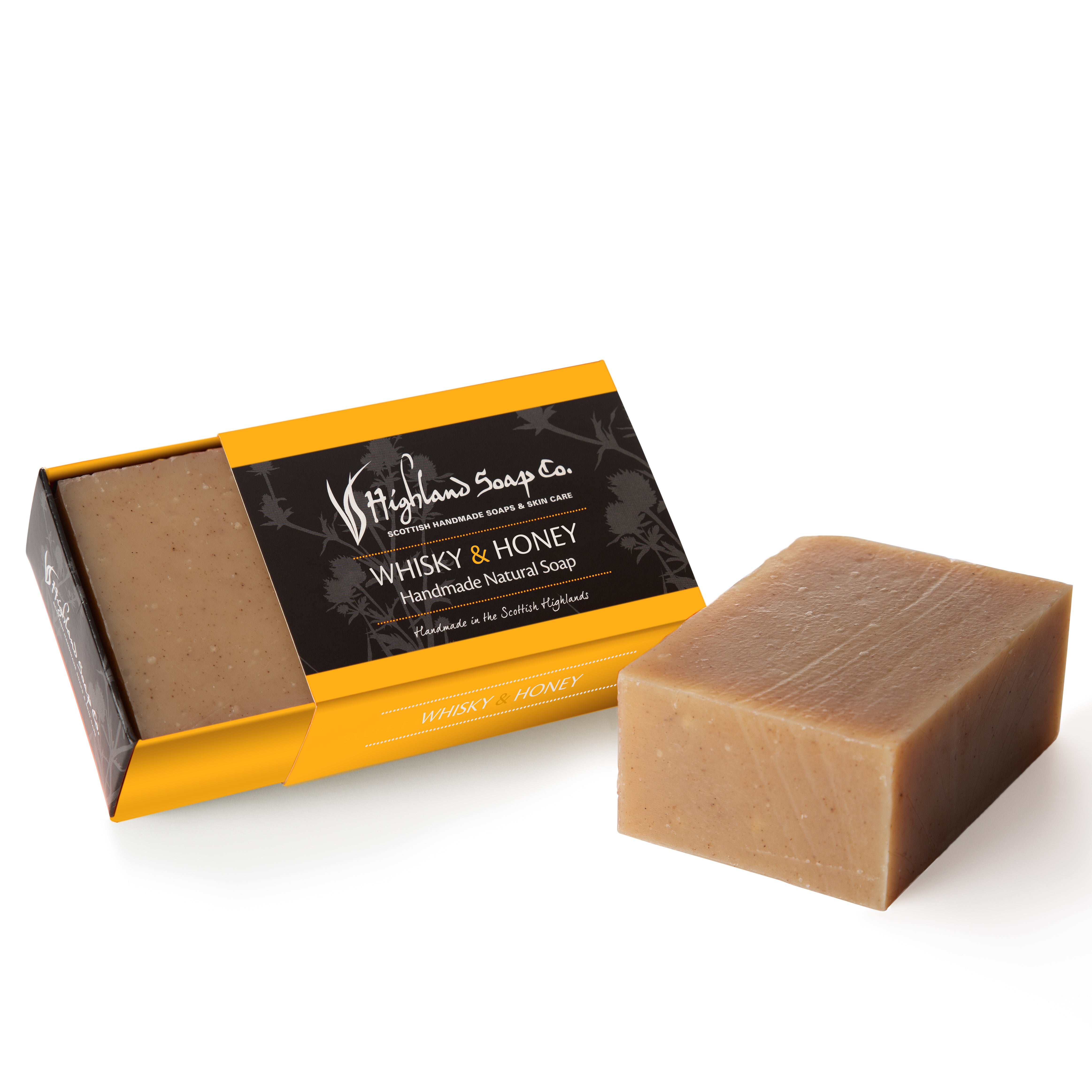 Bar of soap with packaging labeled 'Highlands Soap Co. Whisky & Honey' on a white background