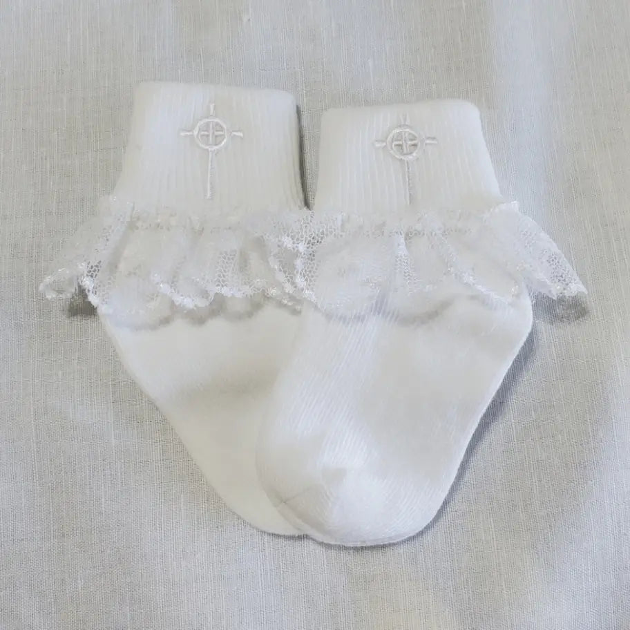 White baby socks with lace trim on a light gray background