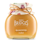 Jar of Mrs. Bridges Banoffee Curd with a decorative lid on a white background