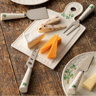 Cheese platter set with cheese and utensils on a wooden surface