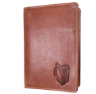 Brown leather passport cover with a harp emblem on a white background