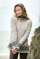Woman wearing a patterned sweater standing outdoors with a blurred background