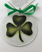 Decorative round ornament with a black shamrock design on a white background