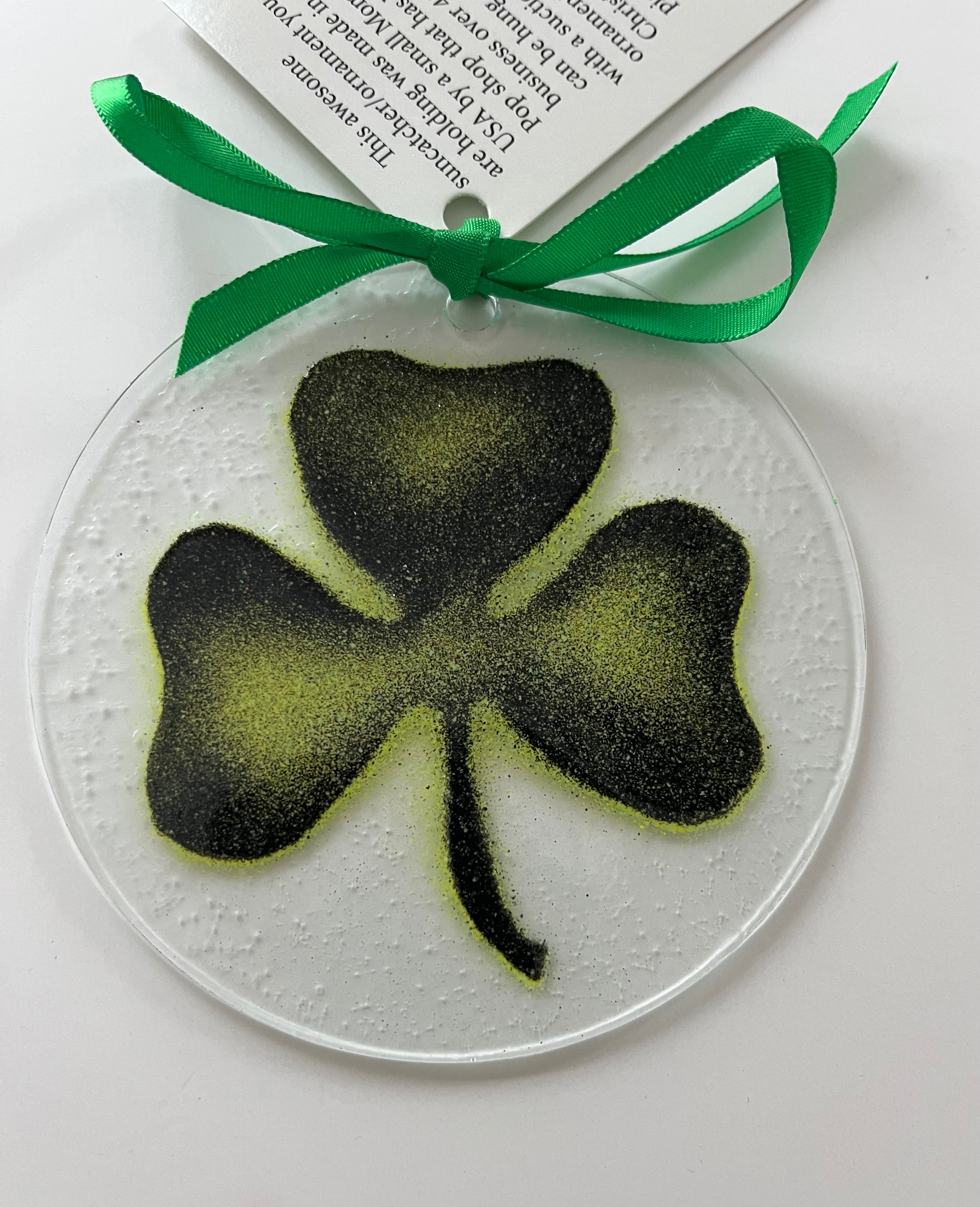 Decorative round ornament with a black shamrock design on a white background