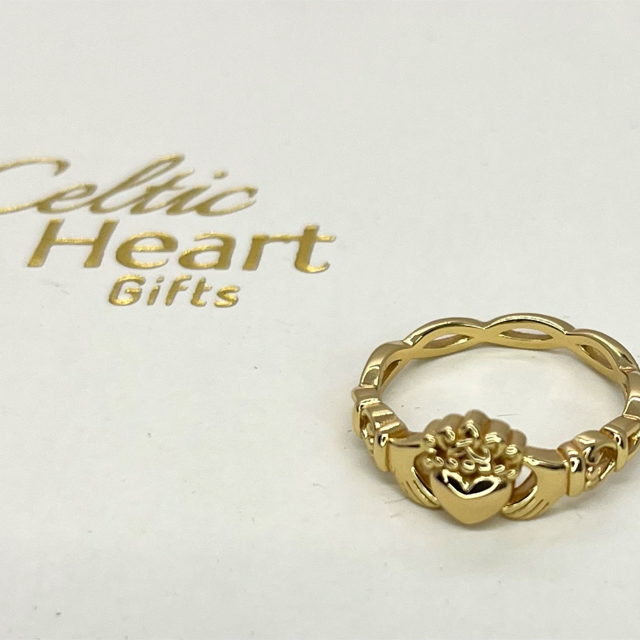 Gold ring with claddagh design on a white card with 'Celtic Heart Gifts' text.