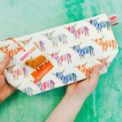 Pouch with colorful yarn design and 'Hairy Coo' branding on a green background