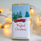 Chocolate bar packaging with Christmas design featuring a red car and trees, text 'Have a Magical Christmas'.