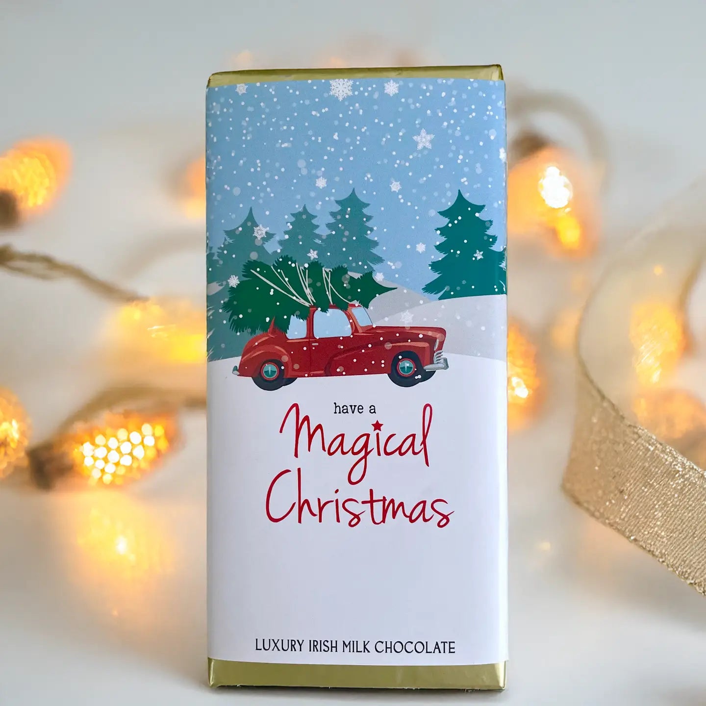 Chocolate bar packaging with Christmas design featuring a red car and trees, text 'Have a Magical Christmas'.