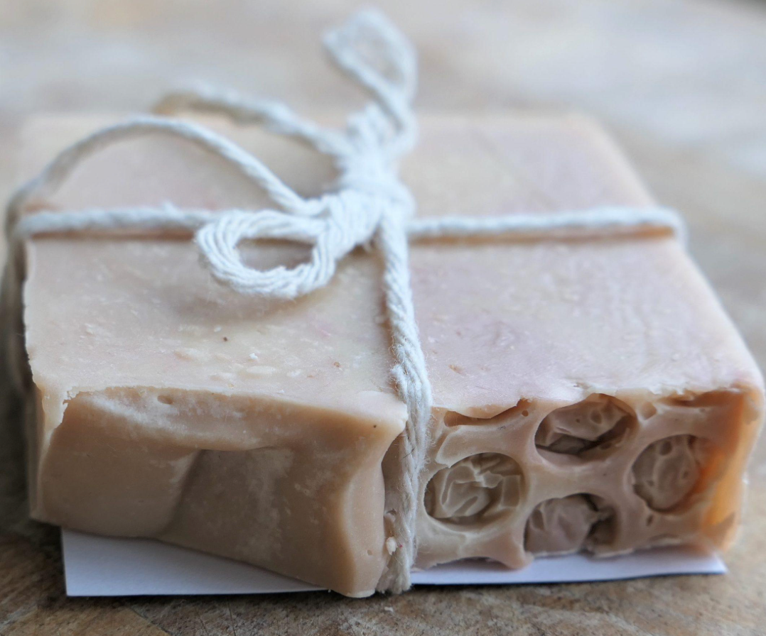 A bar of soap tied with twine on a wooden surface