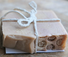 A bar of soap tied with twine on a wooden surface