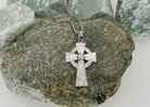 Silver Celtic cross necklace on a rock
