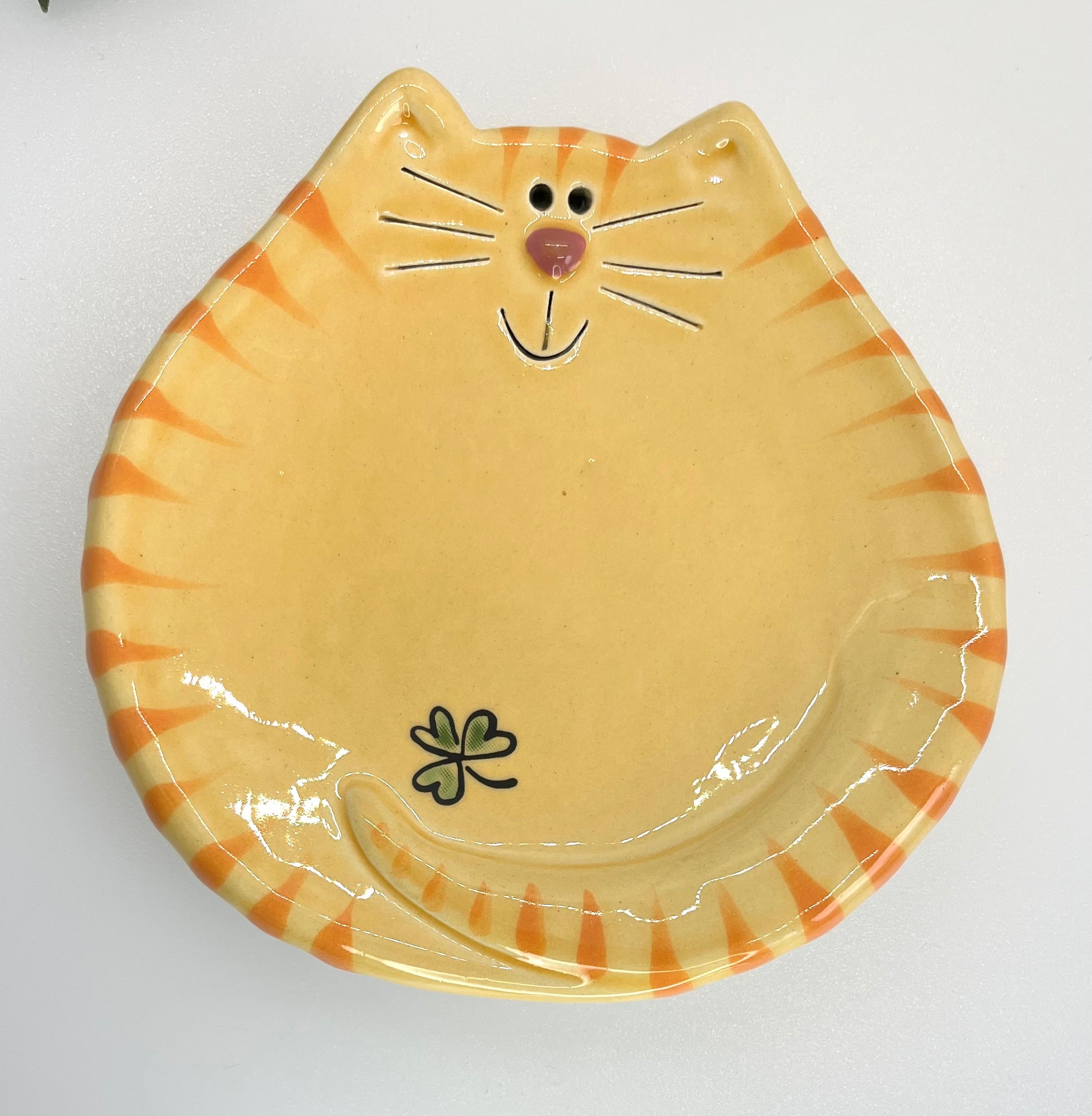 Cat-shaped ceramic plate with striped pattern on a white background