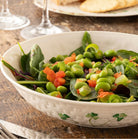Bowl of salad with green beans and tomatoes on a wooden table