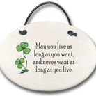 Round ceramic hanging plaque with four-leaf clover design and quote on a white background