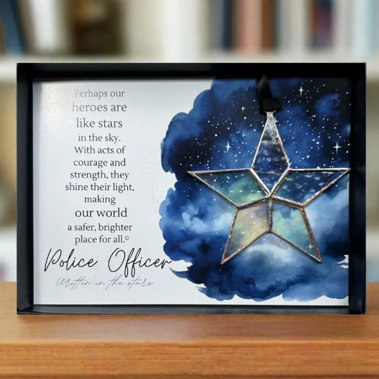Framed artwork with star design and text about police officers on a wooden surface.