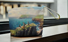 Pouch with a scenic design of birds on a cliff overlooking water.
