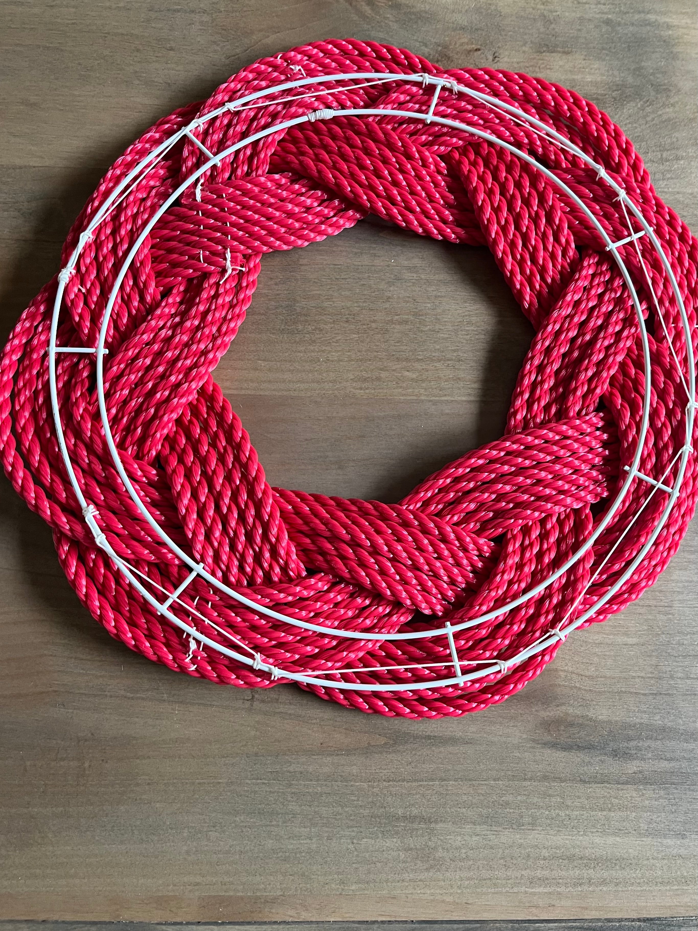 Coiled red rope on a wooden surface