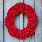 Red braided rope wreath on a wooden background