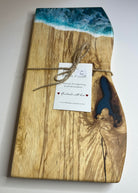 Wooden cutting board with ocean design and a tag on a white background
