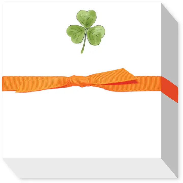 Note pad with orange ribbon and shamrock on a white background