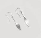 Silver earrings on a light gray background