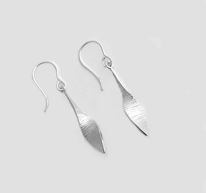 Silver earrings on a light gray background