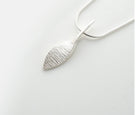 Silver leaf-shaped pendant on a white background