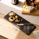 Serving platter with cheese, crackers, and nuts on a wooden table.