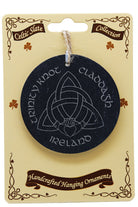 Celtic knot design on a black round ornament with 'Ireland' text, on a decorative beige card.