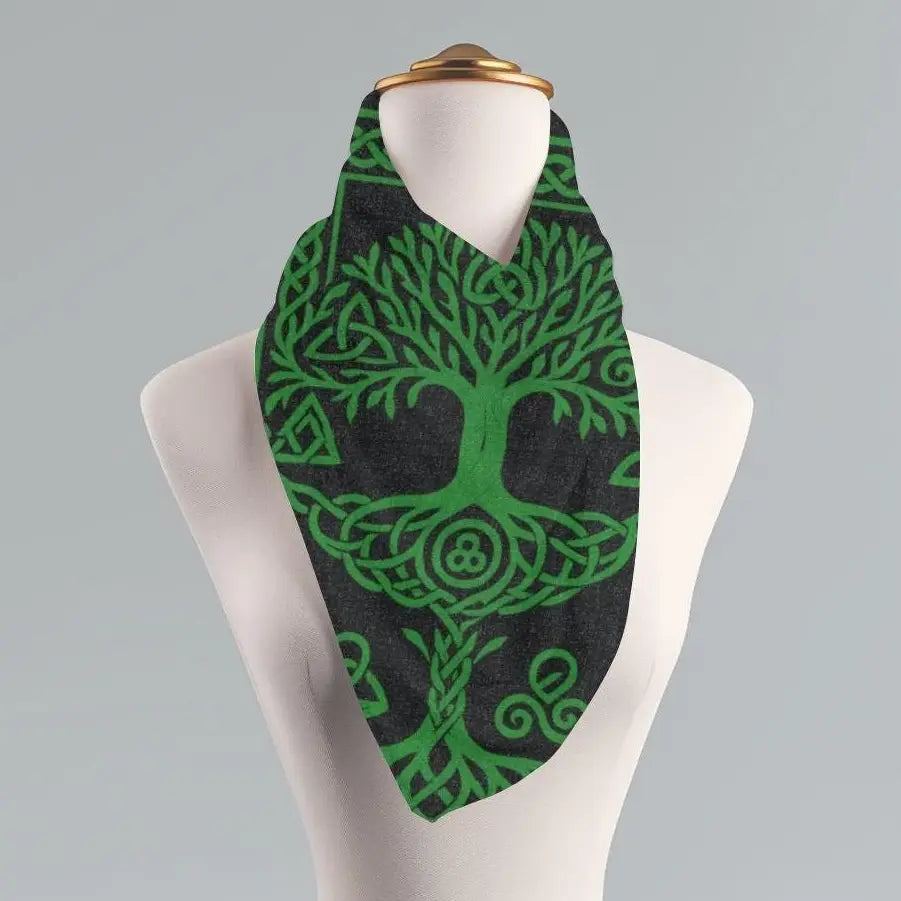 A green Celtic tree of life scarf with intricate knotwork patterns, displayed on a white mannequin torso against a neutral gray background.