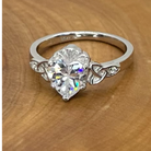 Silver ring with a large diamond on a wooden surface