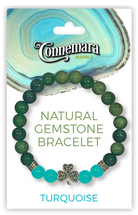 Green and turquoise gemstone bracelet with a shamrock charm on Connemara Marble packaging.