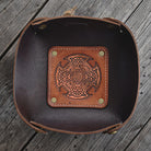 Brown leather tray with Celtic cross design on a wooden surface