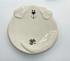 Ceramic dog-shaped plate with a black nose and green clover on a white background