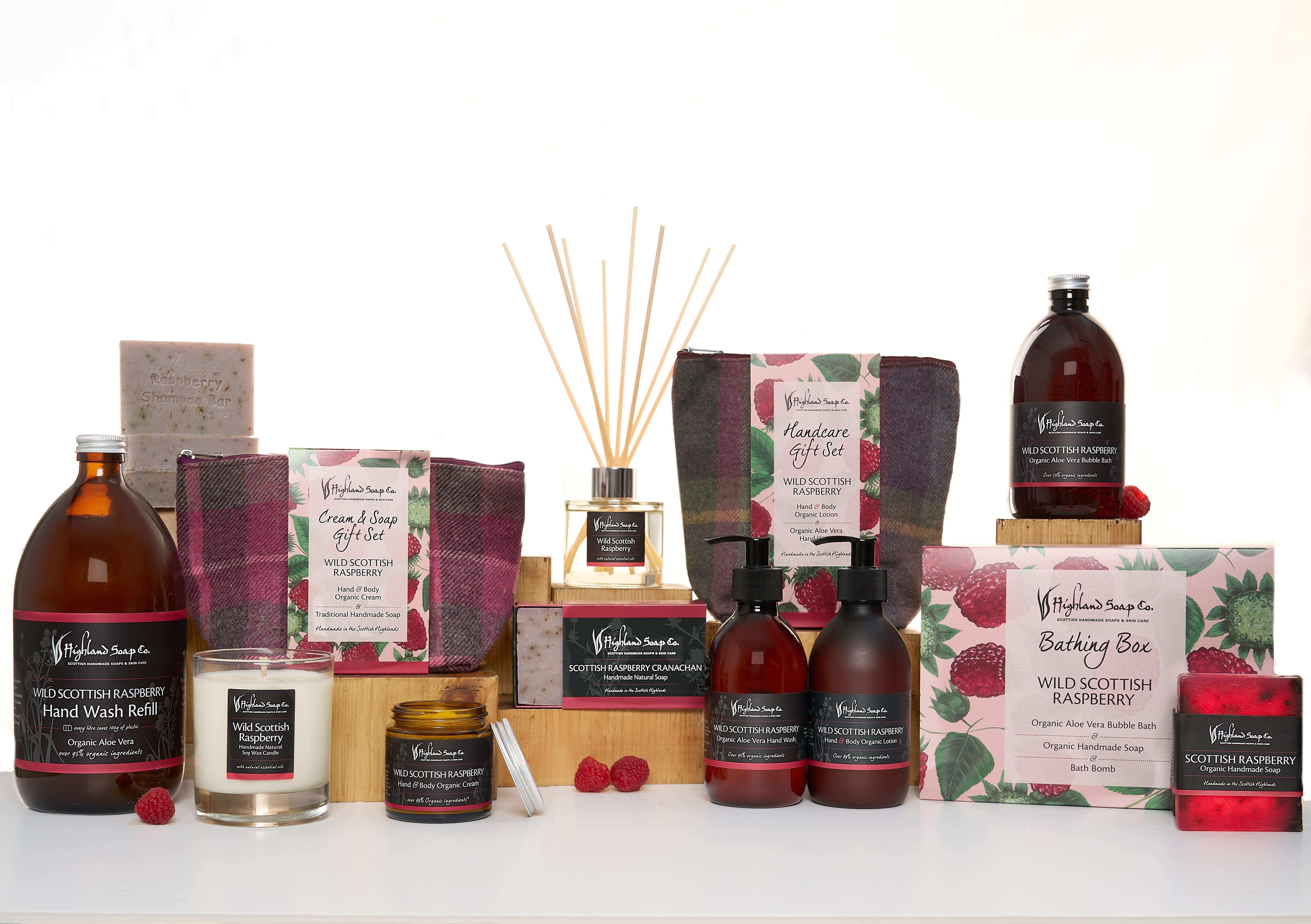 Collection of Wild raspberry Soap products including soap bars, candles, and diffusers on a white background.