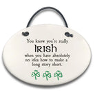 Round ceramic sign with text and shamrock designs on a white background