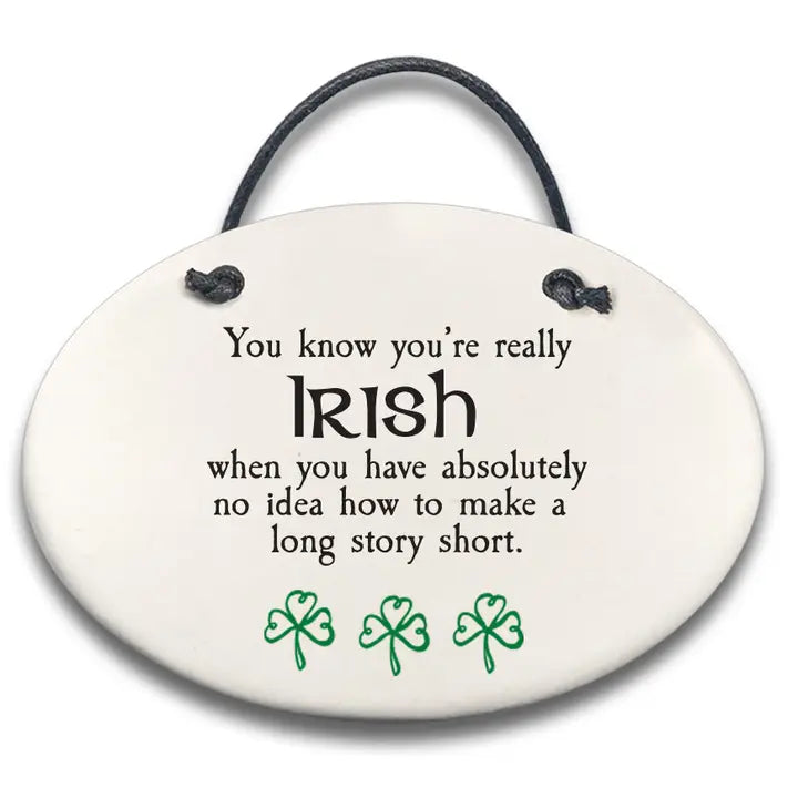 Round ceramic sign with text and shamrock designs on a white background