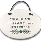 Round ceramic plaque with text 'You're the mom that everyone else wishes they had' and a shamrock on a white background.
