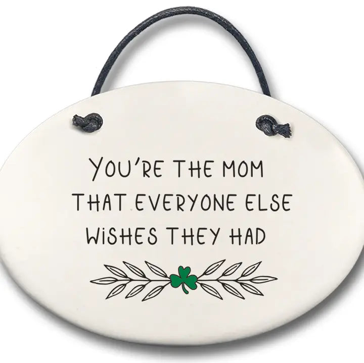 Round ceramic plaque with text 'You're the mom that everyone else wishes they had' and a shamrock on a white background.
